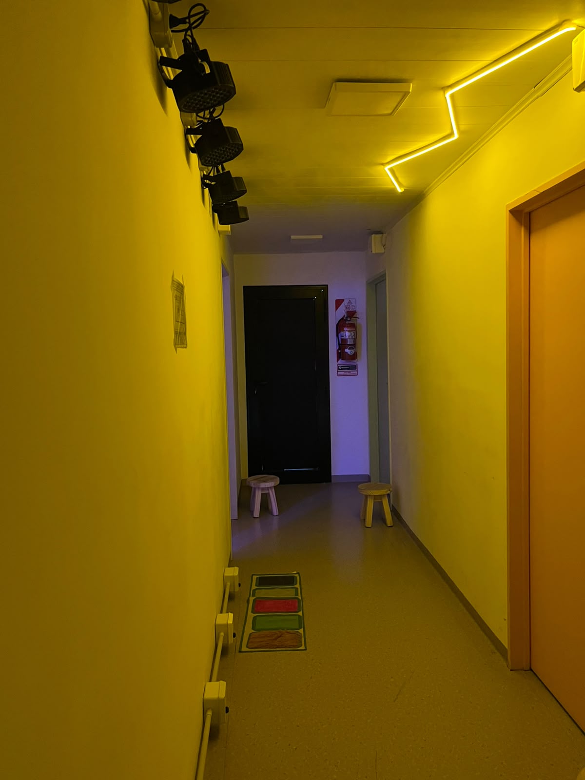 Pasillo con iluminación cálida y juegos en el piso